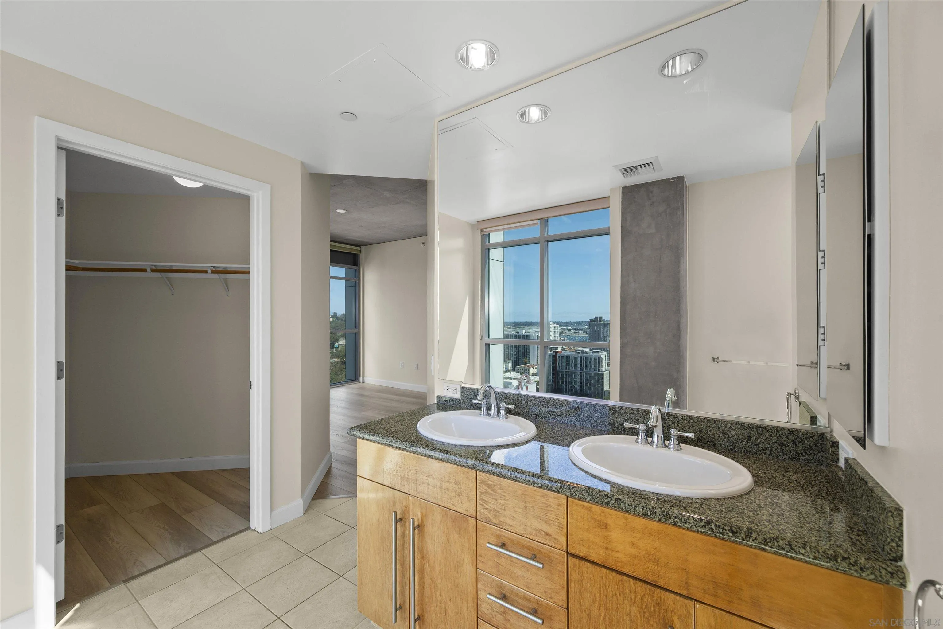 801 Ash Street, Unit 1701 San Diego, CA 92101 - Photo 42 of 44 a bathroom with a granite countertop sink and a mirror