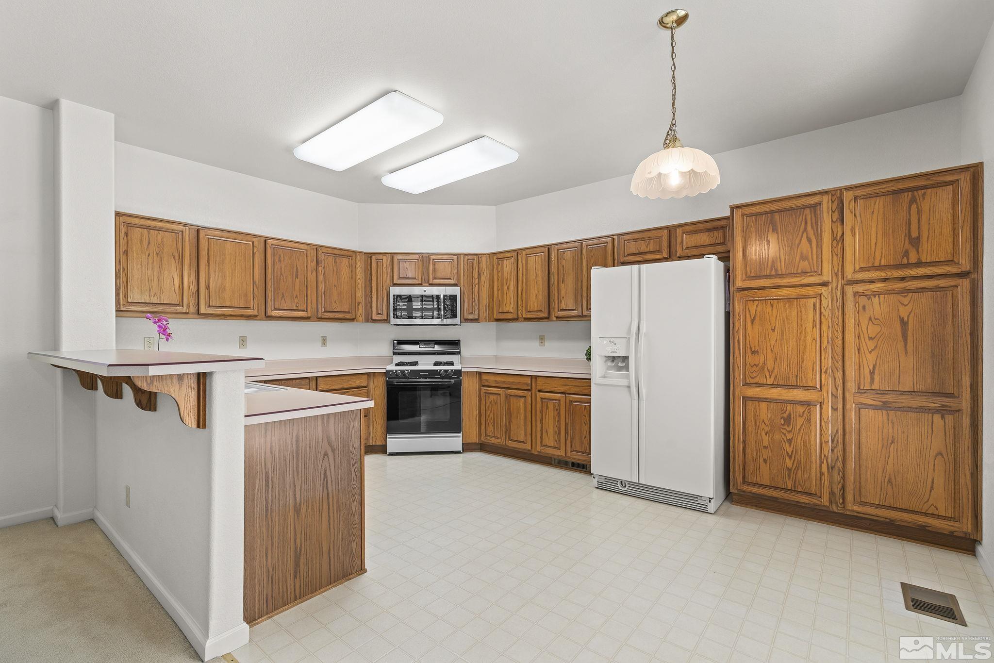 3310 Snake River Drive Reno, NV 89503 - Photo 2 of 33 a kitchen with refrigerator cabinets and wooden floor
