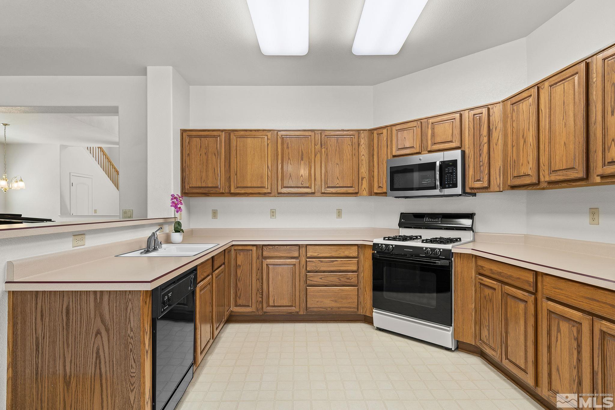3310 Snake River Drive Reno, NV 89503 - Photo 3 of 33 a kitchen with stainless steel appliances granite countertop a sink stove microwave and refrigerator