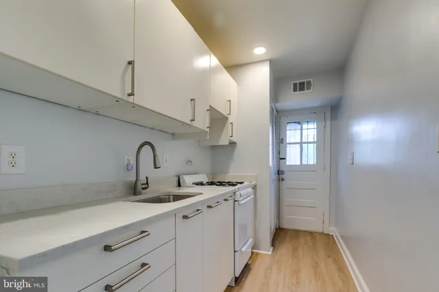 a kitchen with stainless steel appliances a sink stove and cabinets