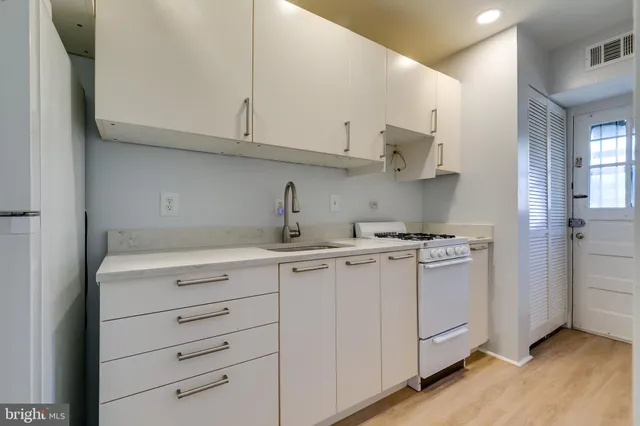 a kitchen with cabinets appliances a sink and a counter top space