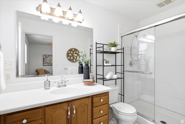 1341 29th Street Ogden, UT 84403 - Photo 18 of 37 Bathroom featuring a single vanity with wood cabinetry, a white countertop, and a large mirror