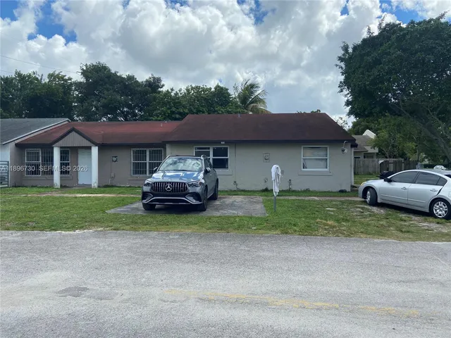a front view of a house with a garden and trees