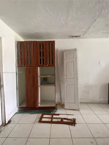 a room with a black white checkered door and a glass door