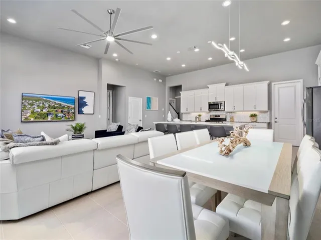 a living room with stainless steel appliances furniture a dining table and chairs