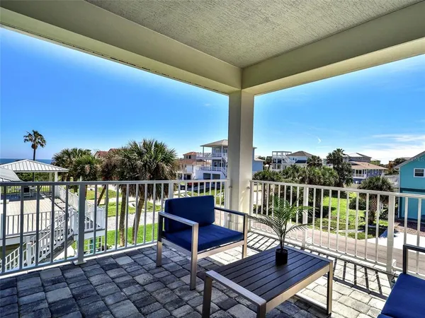 a view of a balcony with wooden floor and outdoor seating