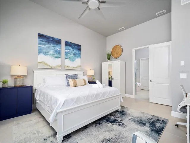 a bedroom with a bed a dresser and painting on the wall