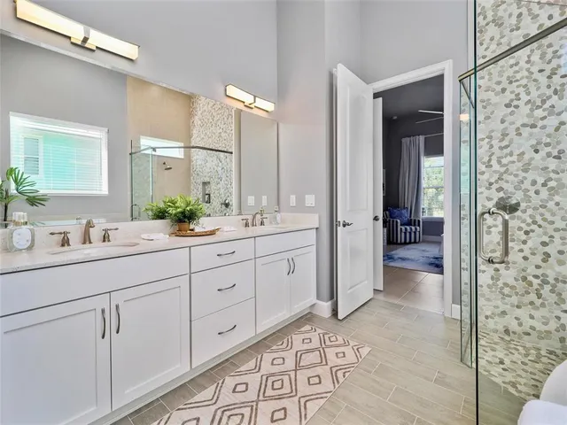 a spacious bathroom with double sink and shower