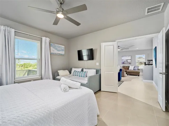 a bedroom with a large bed and a chandelier