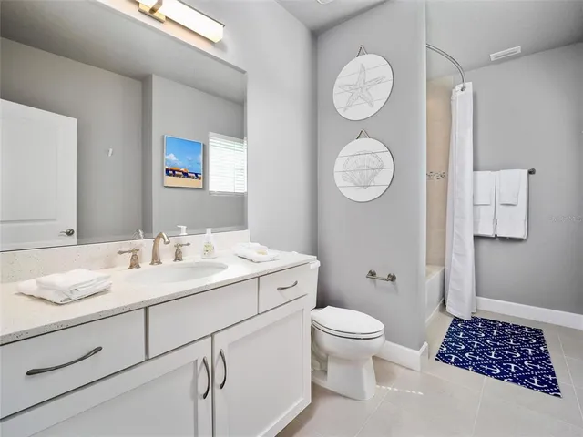 a bathroom with a granite countertop toilet sink and mirror