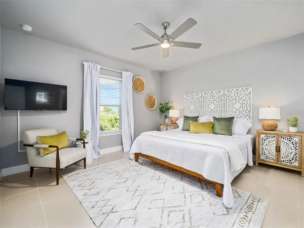 a bedroom with a bed a couch and a chandelier