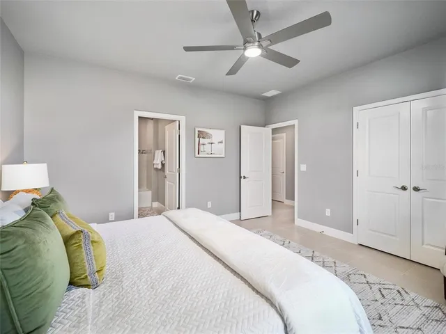 a bedroom with a large bed and a chandelier