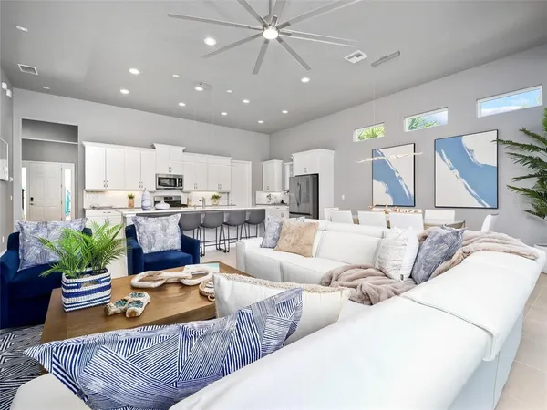 a living room with furniture kitchen and a chandelier