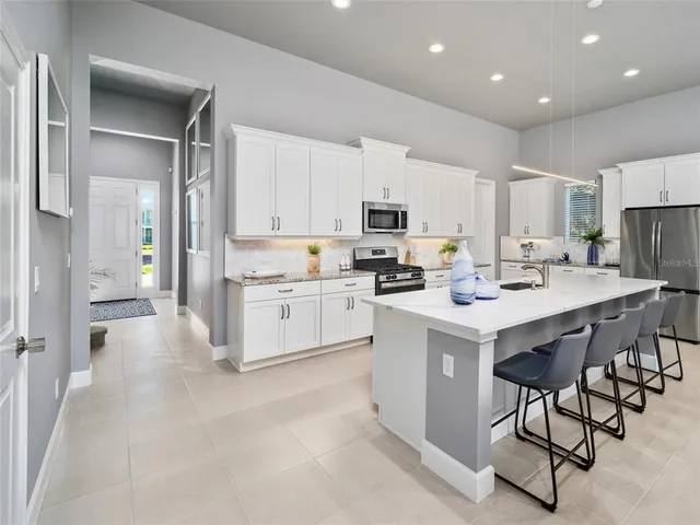 a kitchen with white cabinets and stainless steel appliances