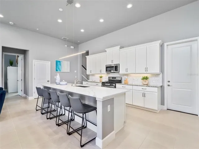 a kitchen with white cabinets stainless steel appliances and dining table