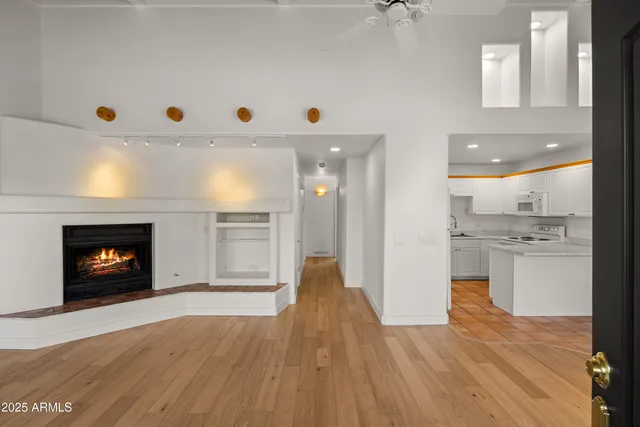 a view of empty room with wooden floor and fireplace
