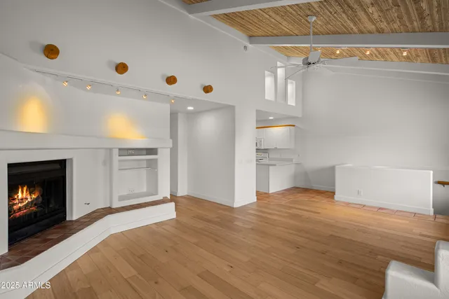 a view of empty room with wooden floor and fireplace