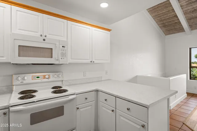 a kitchen with white cabinets and white appliances