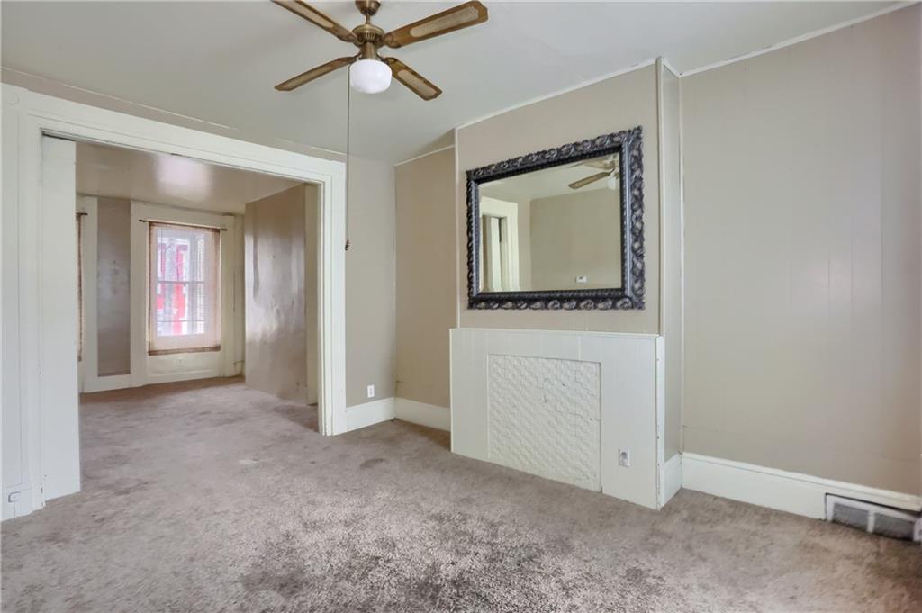 116 Hemlock Street Pittsburgh, PA 15212 - Photo 8 of 38 an empty room that has a window and a ceiling fan