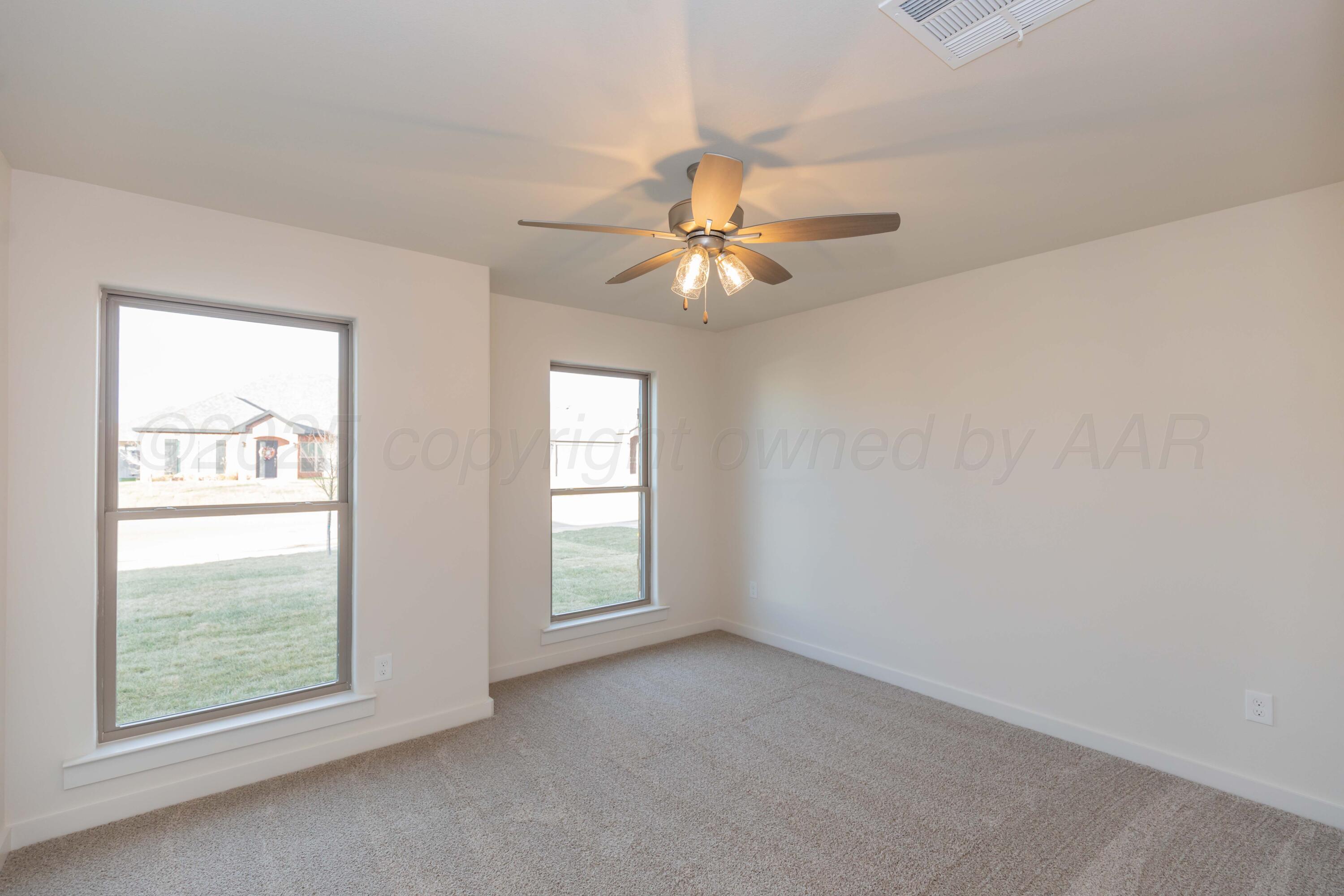 7601 Castleman Road Amarillo, TX 79119 - Photo 11 of 25 an empty room with windows and fan