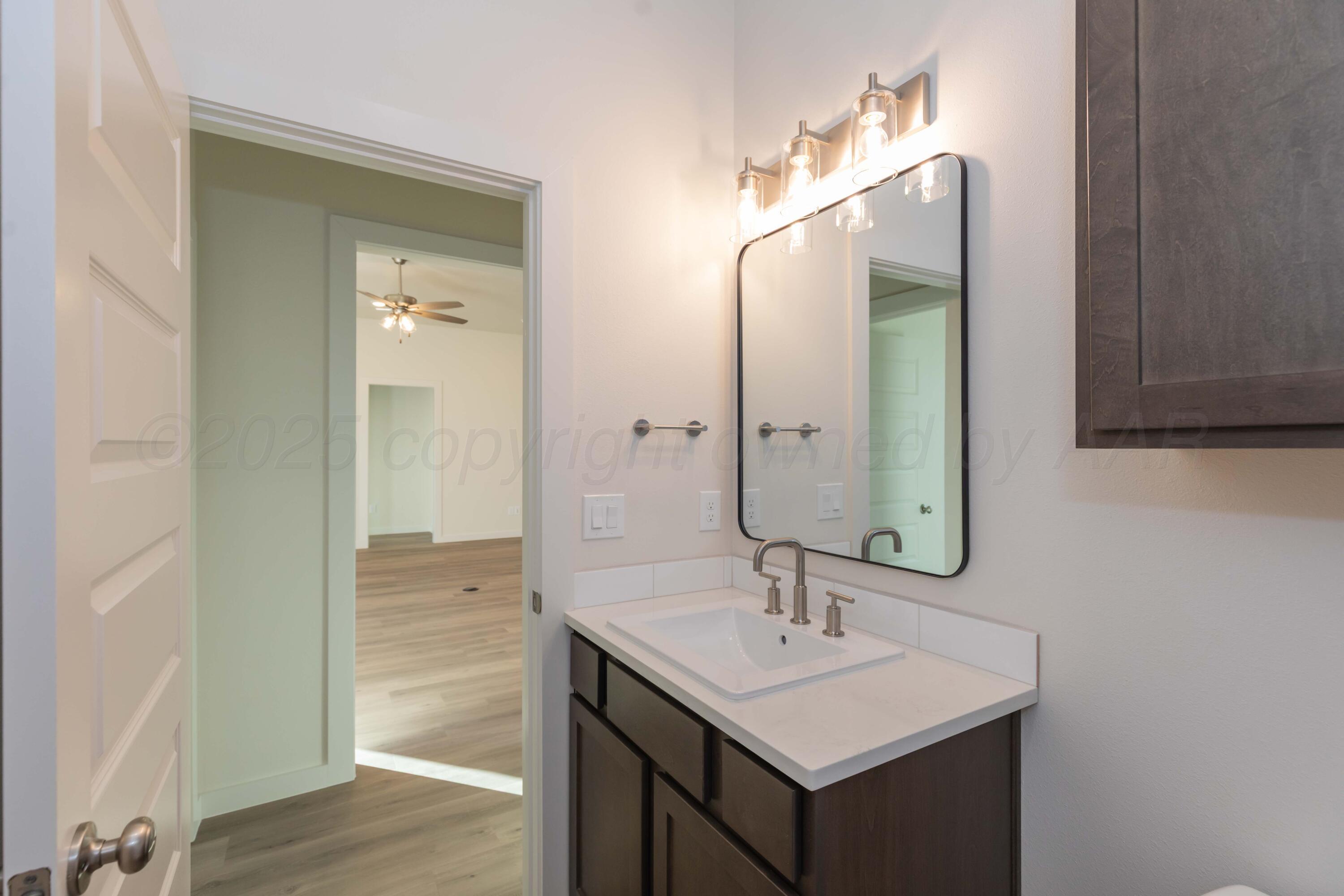 7601 Castleman Road Amarillo, TX 79119 - Photo 15 of 25 a bathroom with a sink a mirror and a shower