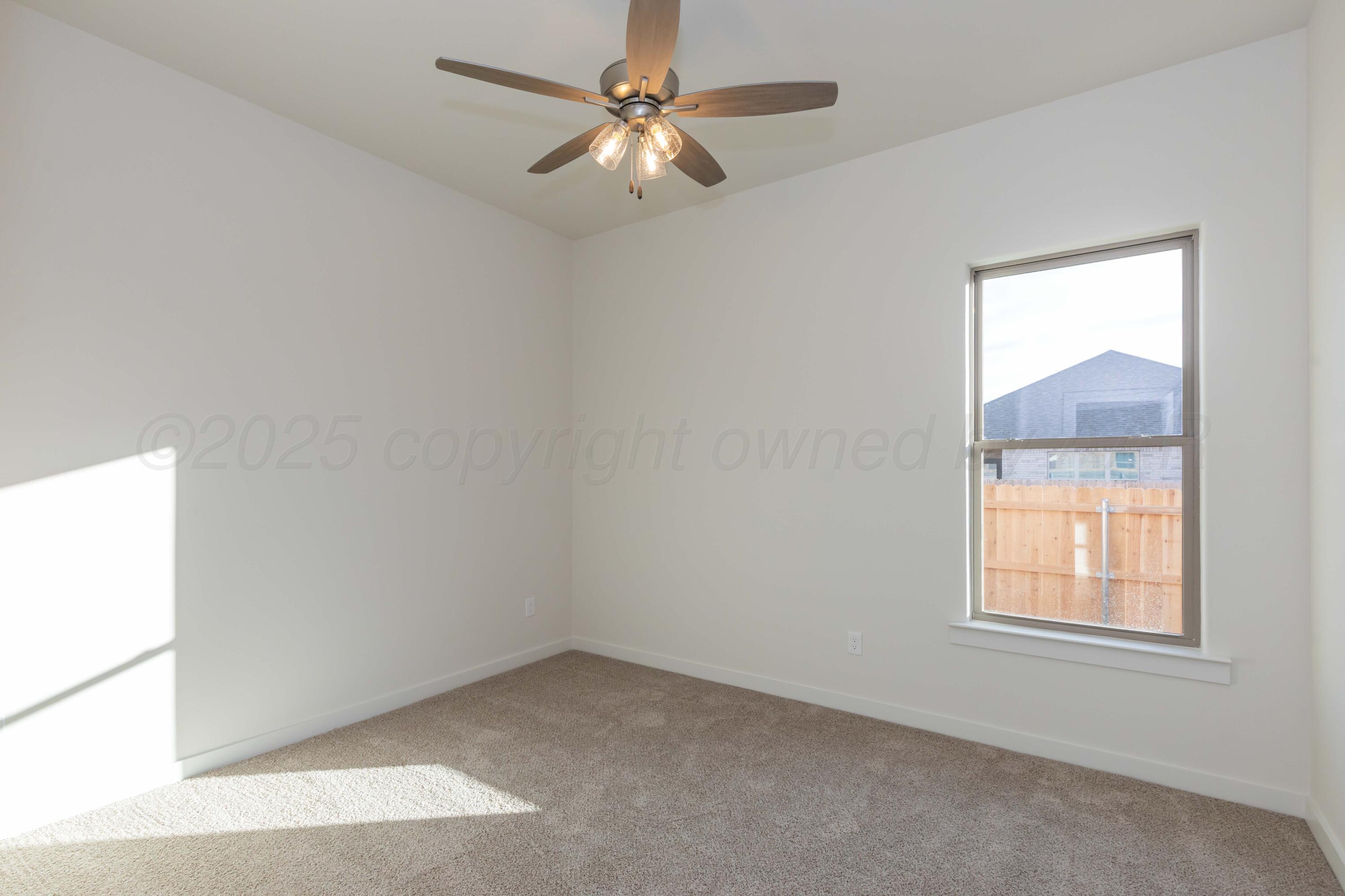 7601 Castleman Road Amarillo, TX 79119 - Photo 16 of 25 an empty room with a window and a fan