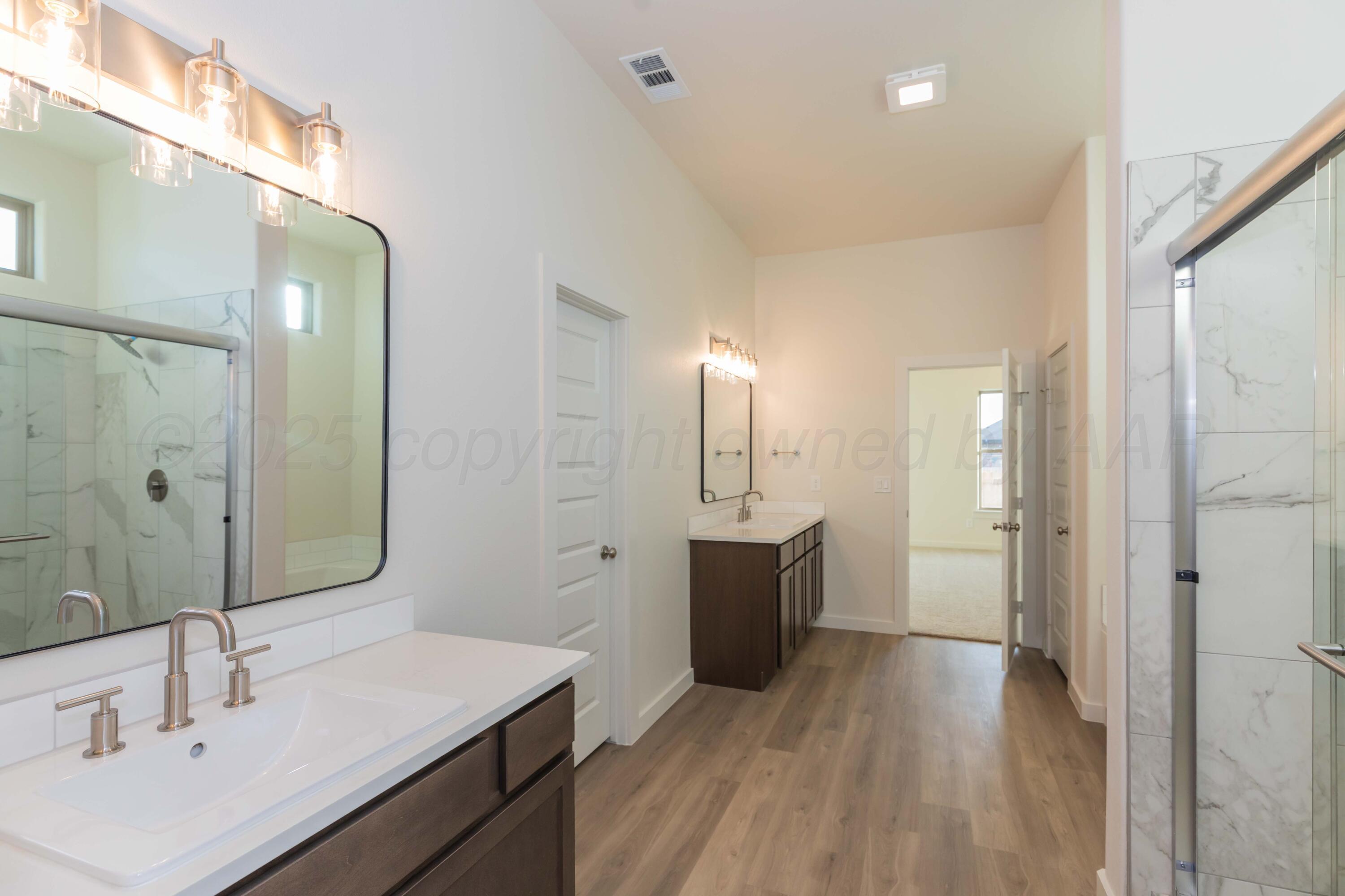 7601 Castleman Road Amarillo, TX 79119 - Photo 19 of 25 a bathroom with a sink and a mirror