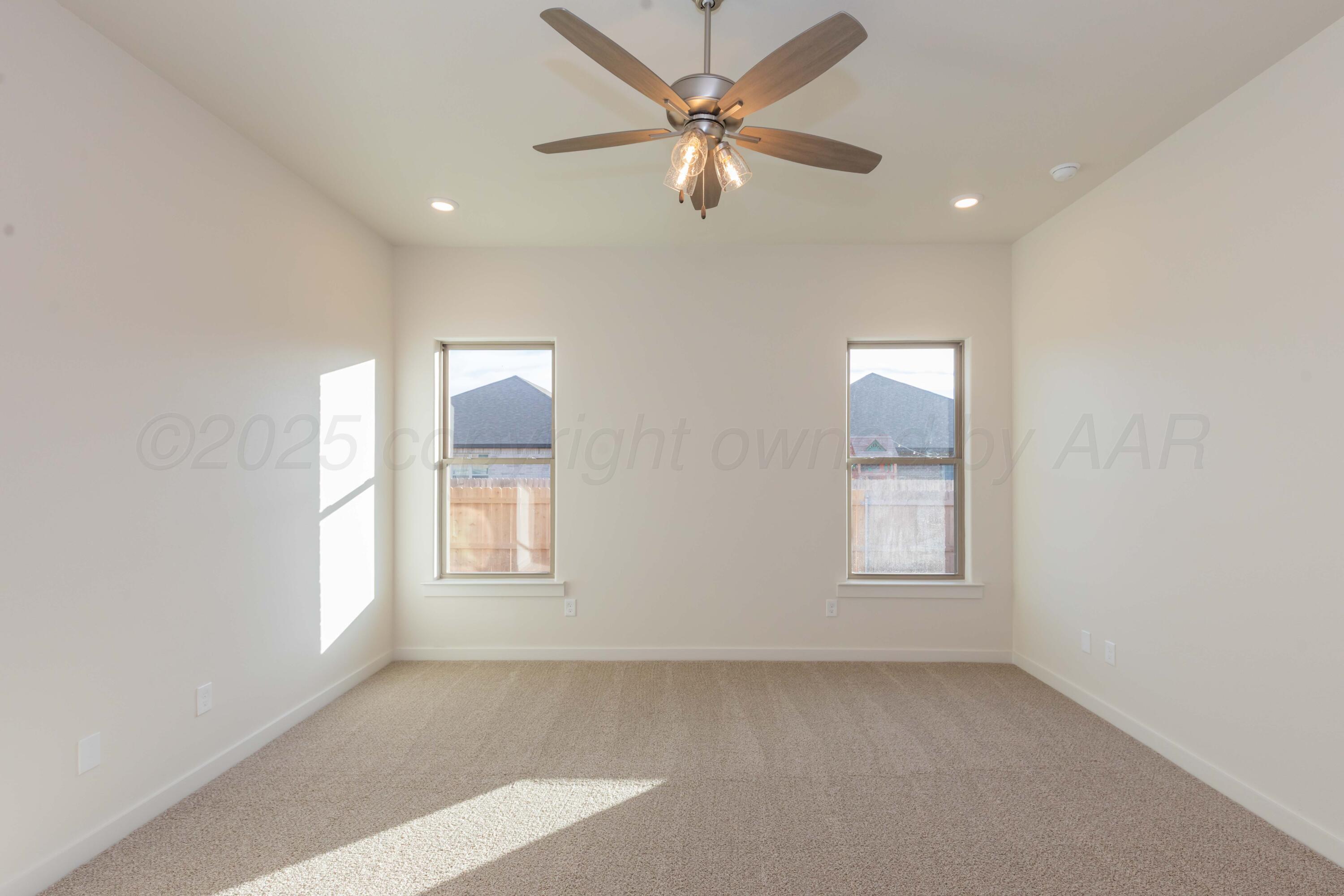 7601 Castleman Road Amarillo, TX 79119 - Photo 20 of 25 an empty room with chandelier fan and windows