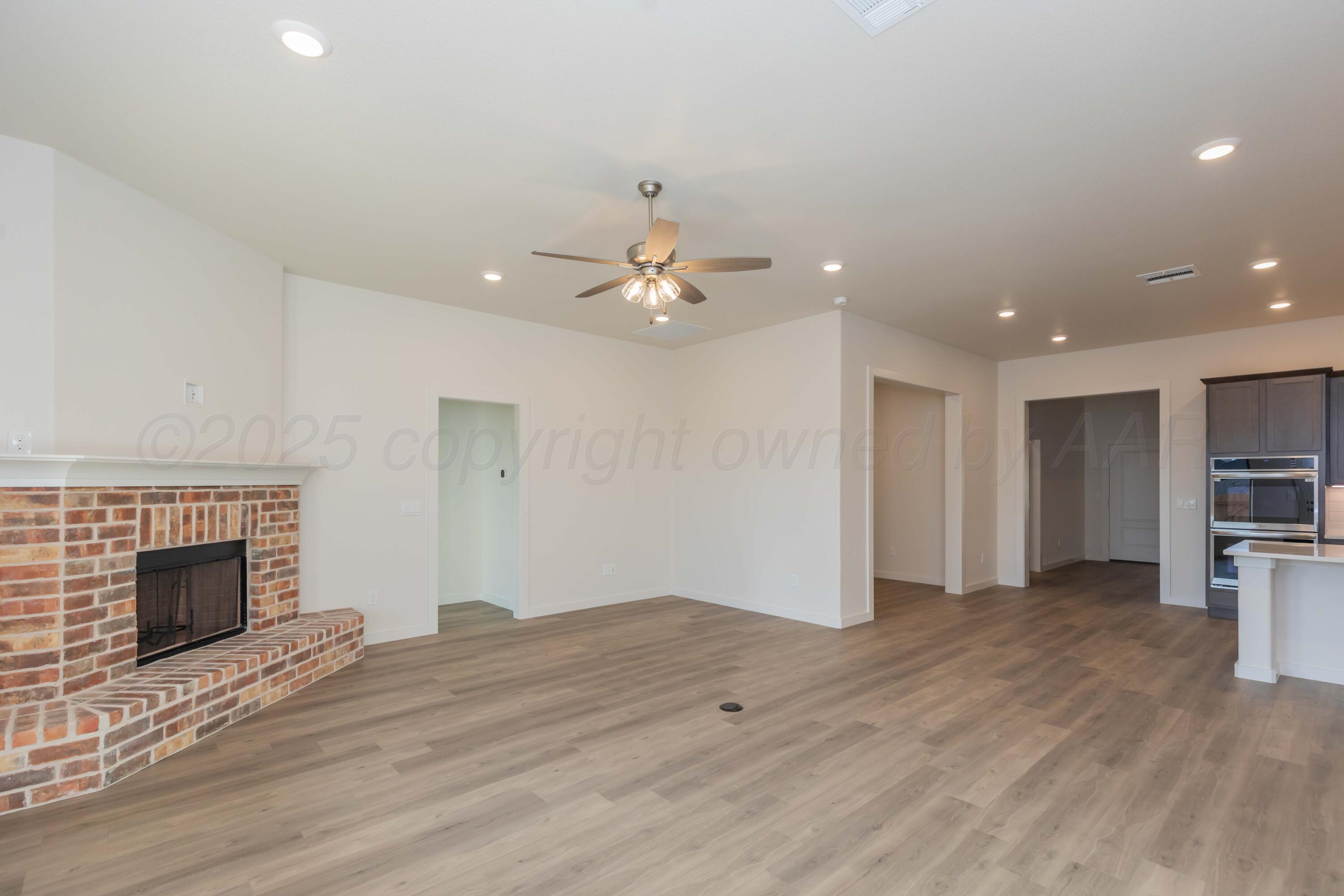 7601 Castleman Road Amarillo, TX 79119 - Photo 3 of 25 wooden floor in an empty room with a fireplace