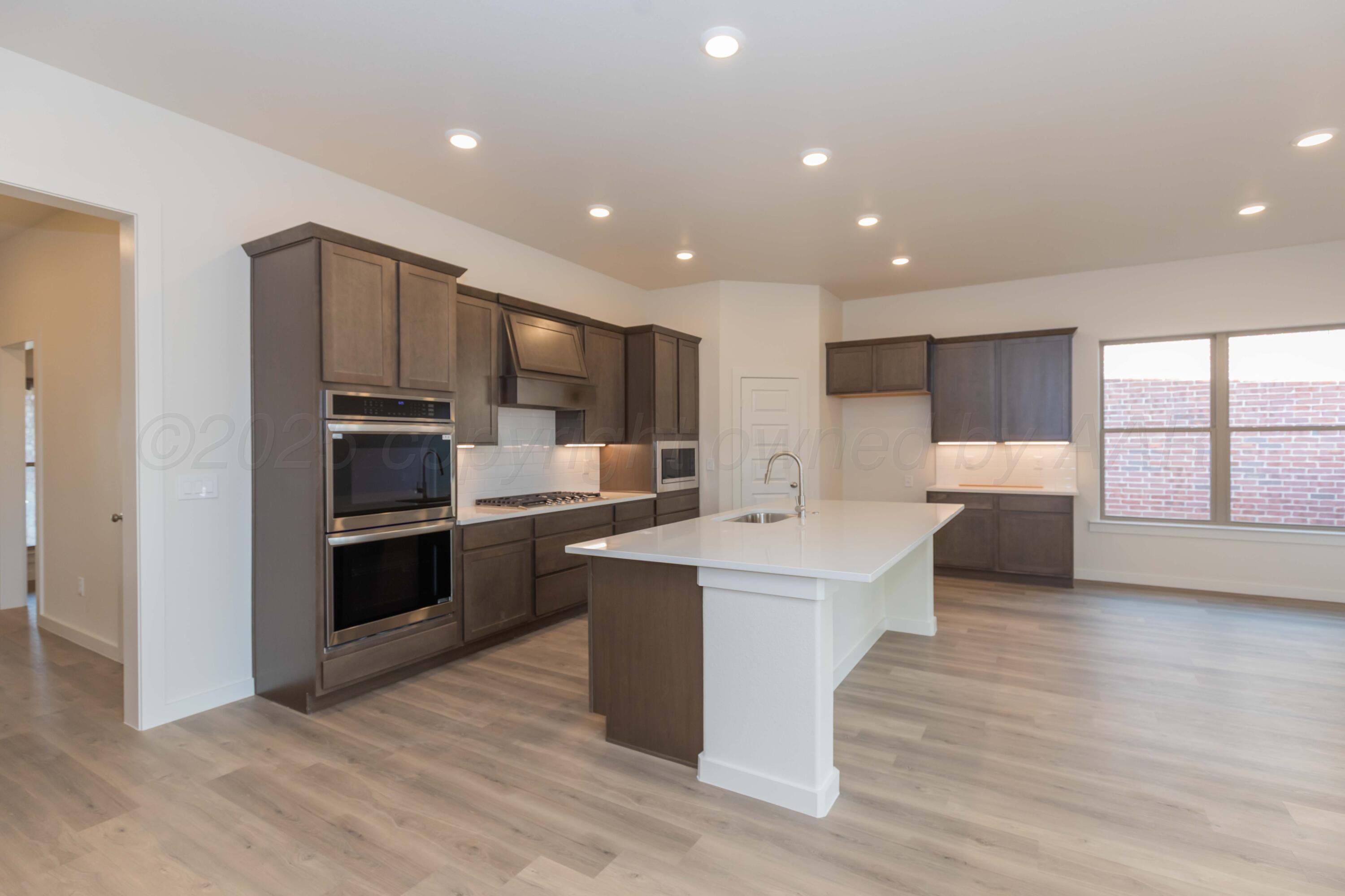 7601 Castleman Road Amarillo, TX 79119 - Photo 6 of 25 a living room with stainless steel appliances kitchen island granite countertop a stove and a sink