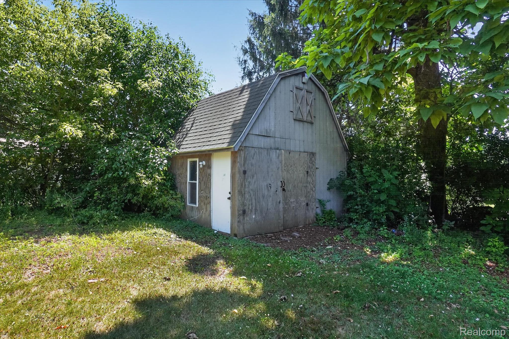 508 Deland Road Flushing, MI 48433 - Photo 36 of 38 Barn-style shed featuring a shingled gambrel roof and natural wood siding