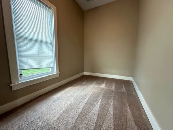 an empty room with windows and closet