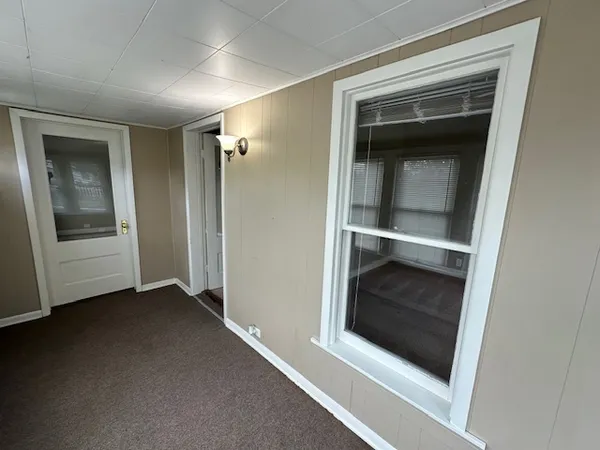 a view of an empty room with a fireplace and wooden cabinet