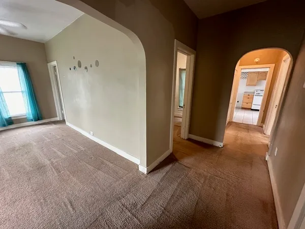 a view of an empty room with a ceiling fan and window