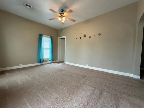 an empty room with closet and a chandelier fan