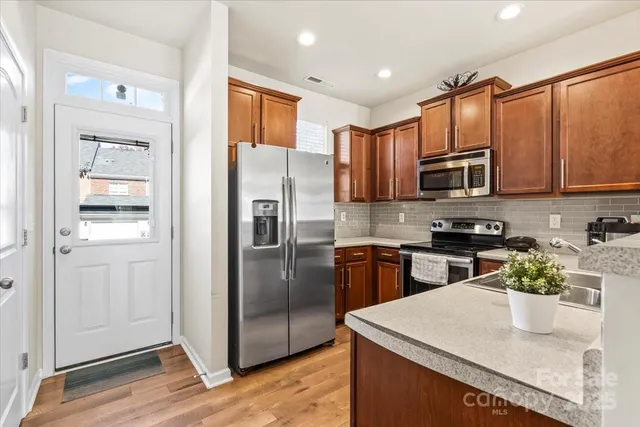 a kitchen with stainless steel appliances granite countertop a refrigerator stove microwave and sink