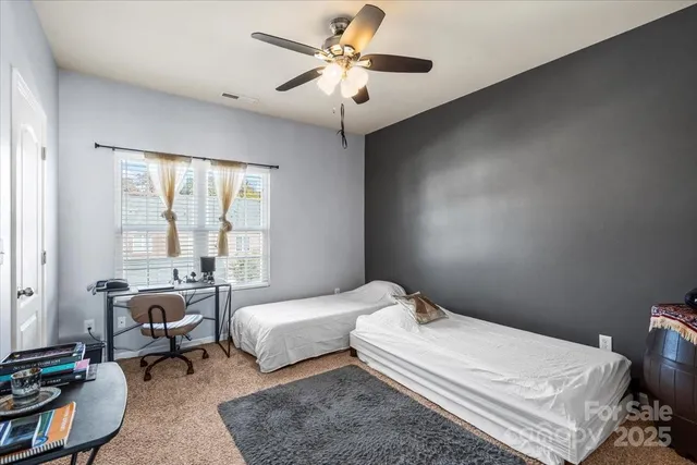 a bedroom with a bed a couch and a chandelier