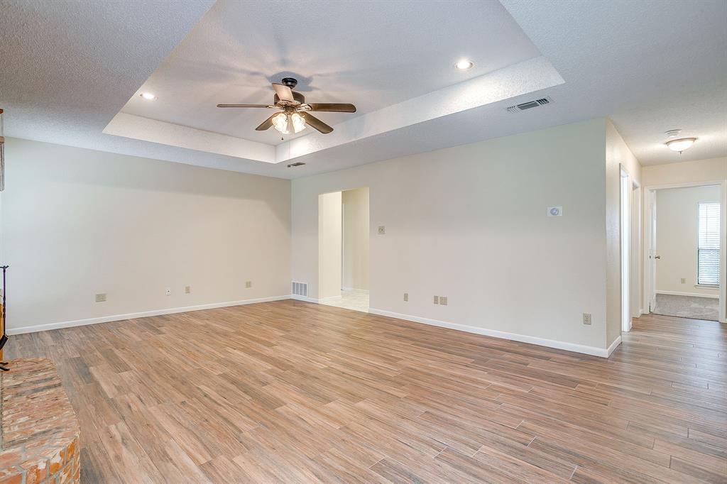8613 Silver Creek Road White Settlement, TX 76108 - Photo 7 of 40 a view of a room with wooden floor and ceiling fan