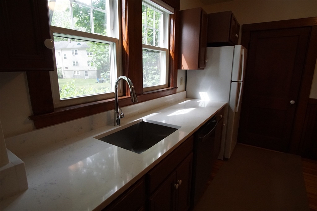 754 Massachusetts Avenue, Unit 1 Lexington, MA 02421 - Photo 8 of 17 a kitchen with a sink a window and cabinets