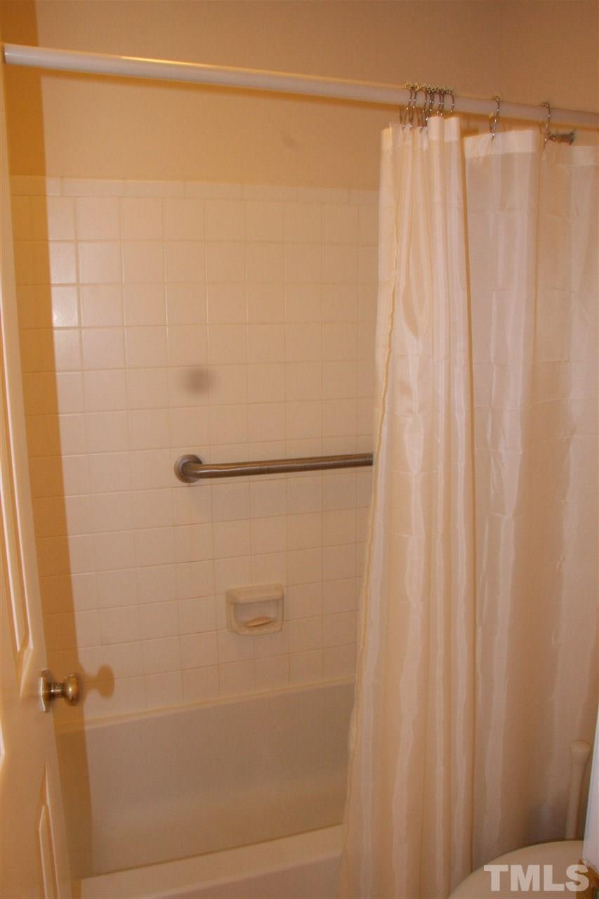 7040 Sandy Forks Road, Unit 105 Raleigh, NC 27615 - Photo 16 of 21 a bathroom with a shower and a shower curtain