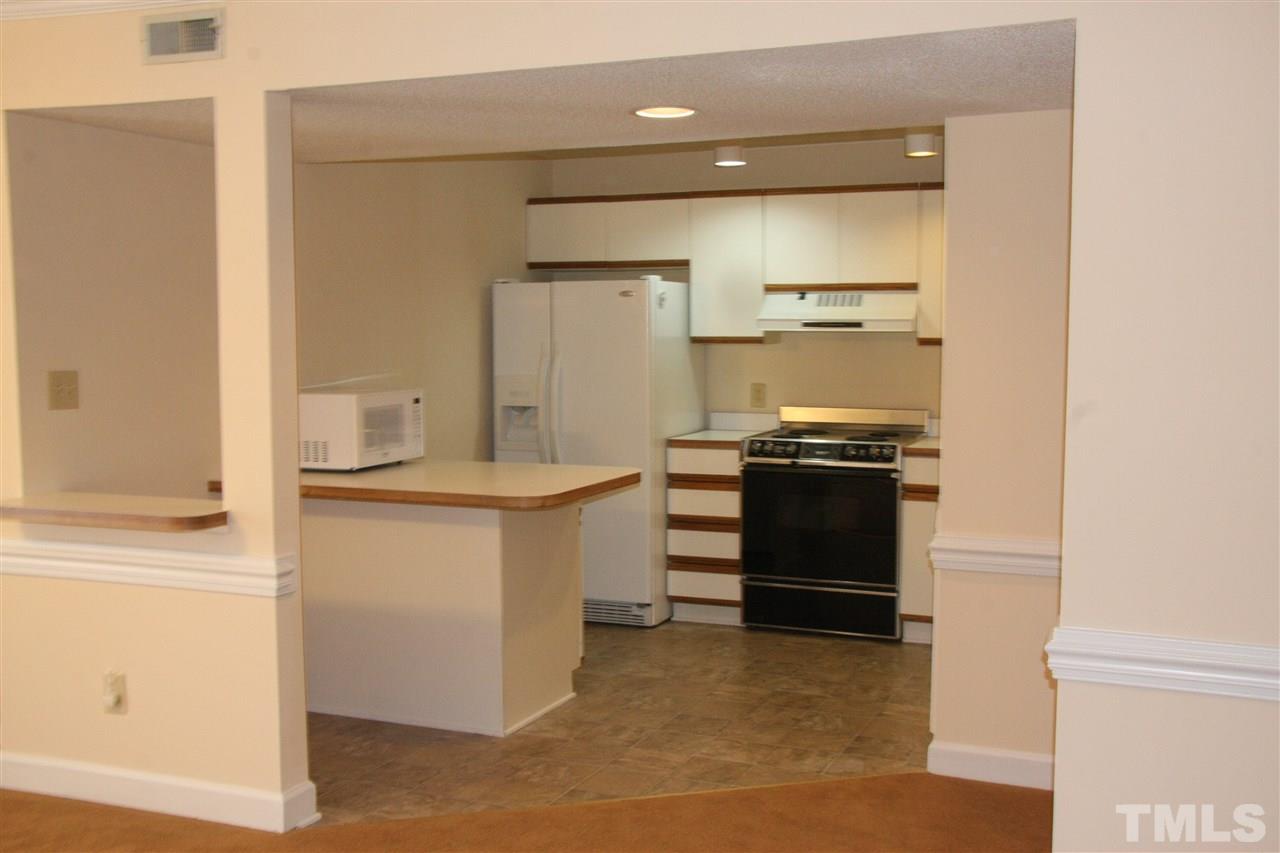 7040 Sandy Forks Road, Unit 105 Raleigh, NC 27615 - Photo 9 of 21 a kitchen with a refrigerator and a stove