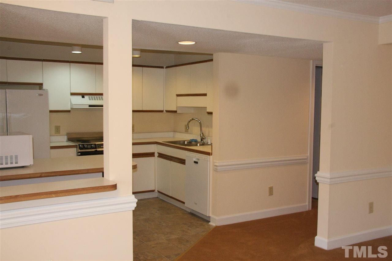 7040 Sandy Forks Road, Unit 105 Raleigh, NC 27615 - Photo 10 of 21 a kitchen with a refrigerator and cabinets