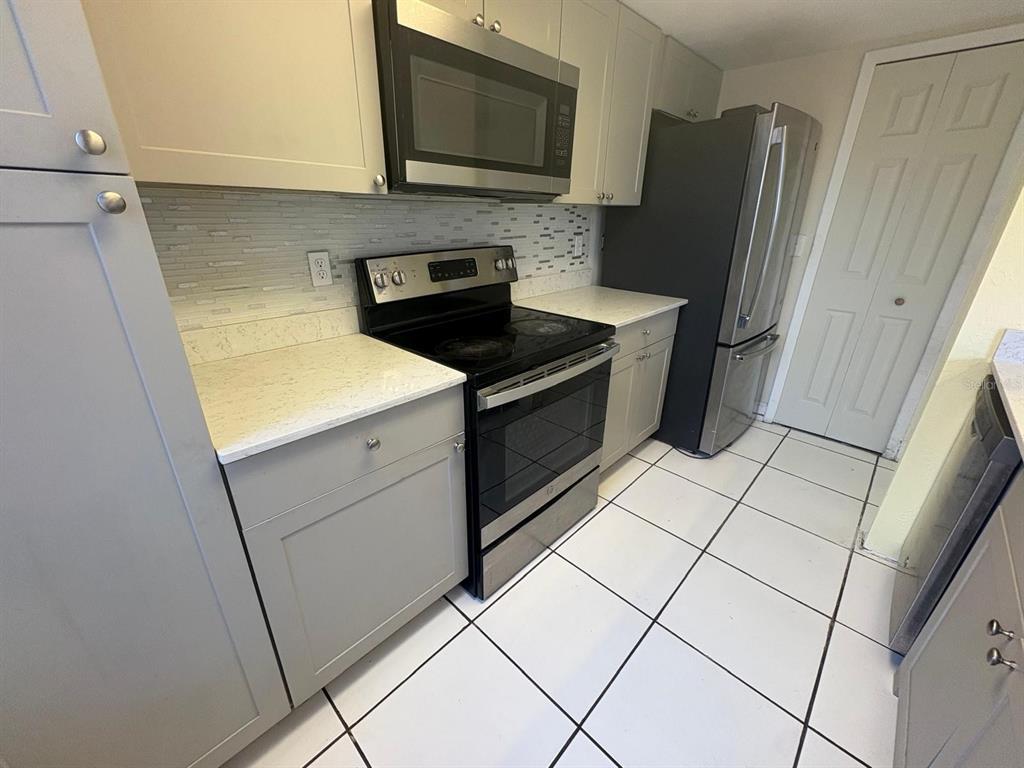 4033 Henley Road, Unit 1707 Orlando, FL 32839 - Photo 19 of 66 a kitchen with stainless steel appliances a refrigerator sink and microwave