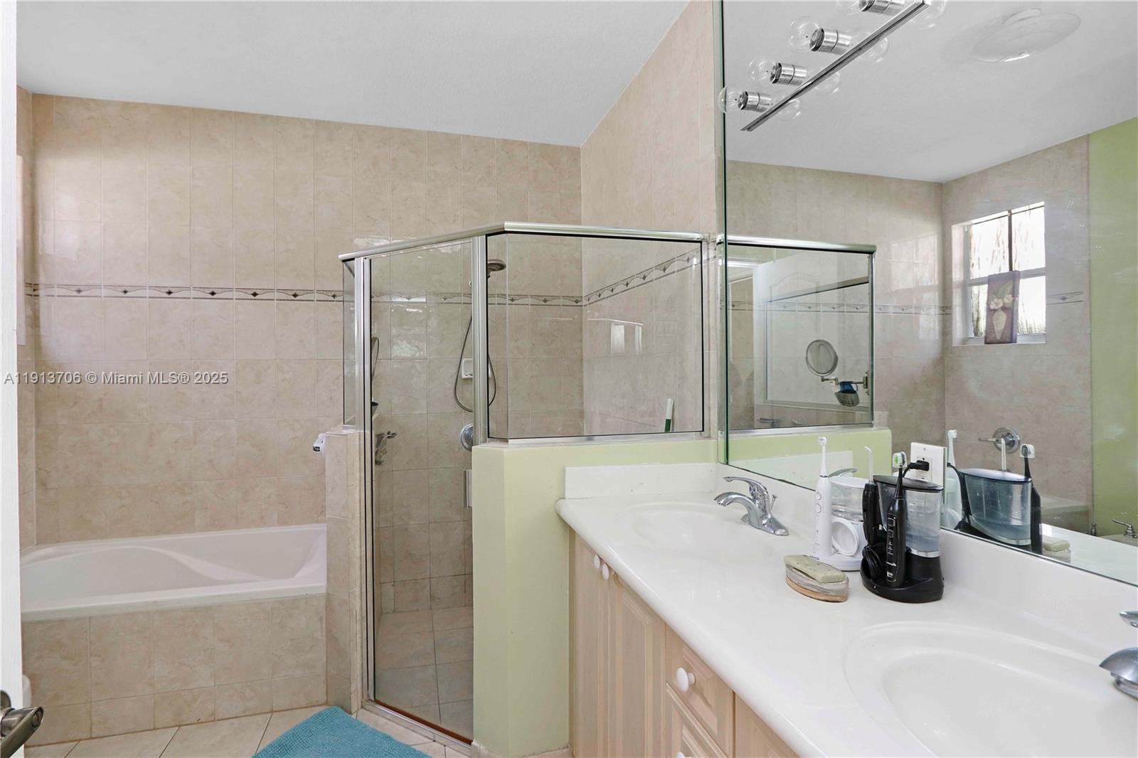 15382 Southwest 16th Terrace Miami, FL 33185 - Photo 15 of 26 a bathroom with a granite countertop sink a mirror and a bathtub