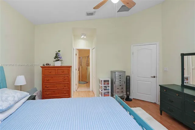 a bedroom with a bed and a dresser next to a window