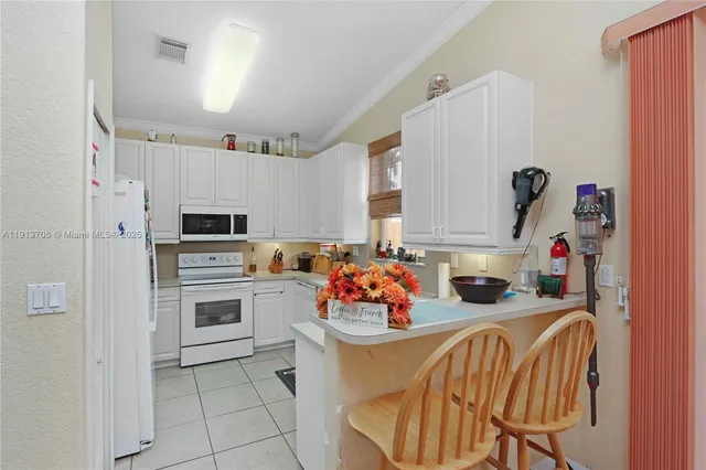 a kitchen with stainless steel appliances a stove a sink dishwasher and white cabinets with wooden floor