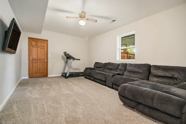 a living room with furniture a flat screen tv and a window