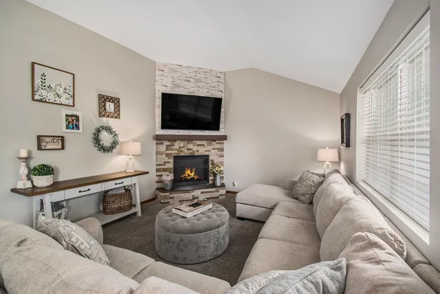a living room with furniture a flat screen tv and a fireplace