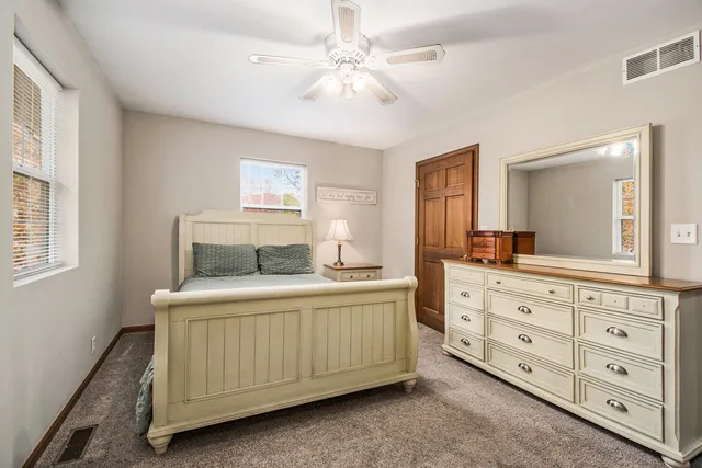 a bedroom with a bad and dresser with the dresser