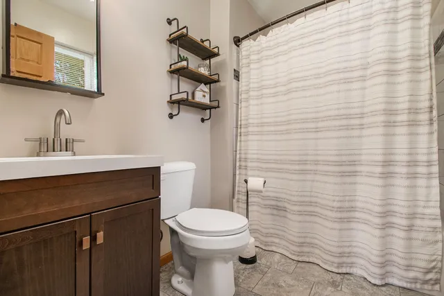 a bathroom with a sink a toilet and shower curtain